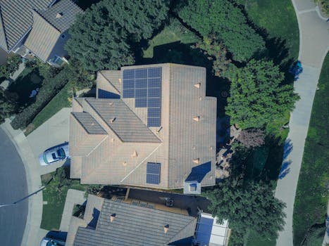 Top-down aerial view of a house with solar panels, showcasing modern renewable energy solutions.